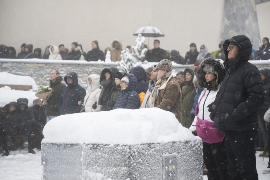 Am Unglücksort in Crans-Montana haben sich die Menschen trotz starkem Schneefall versammelt.