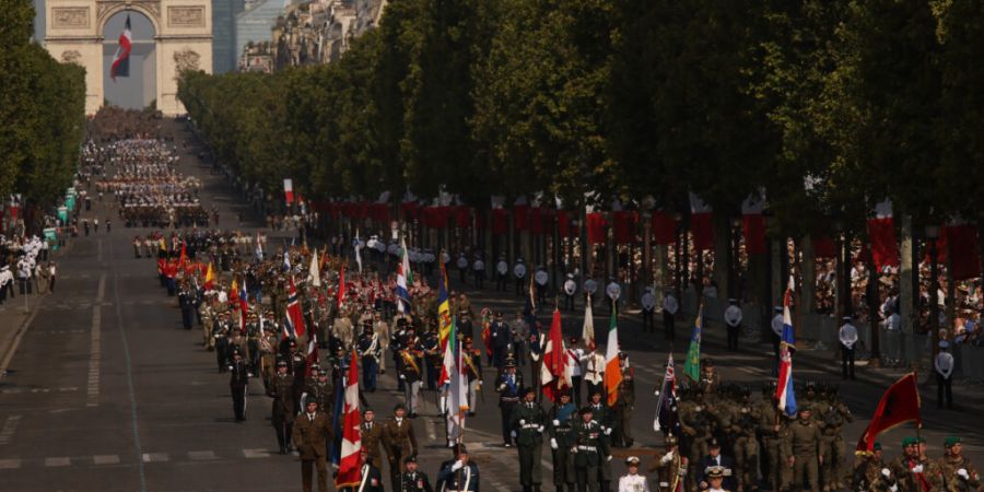 Truppen der sogenannten «Koalition der Willigen» marschieren während der Militärparade zum Bastille-Tag auf den Champs-Elysees. Foto: Thomas Padilla/AP/dpa