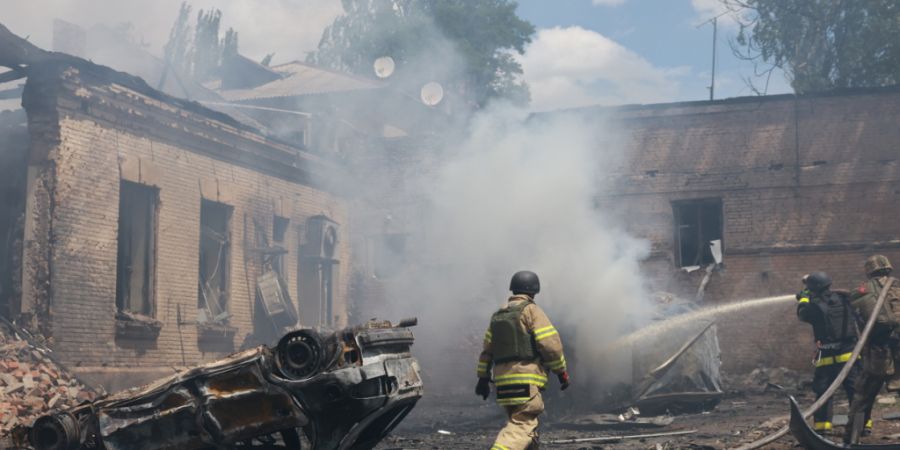 ARCHIV - Rettungskräfte löschen einen Brand in Saporischschja. Foto: Evgeniy Maloletka/AP/dpa/Archivbild