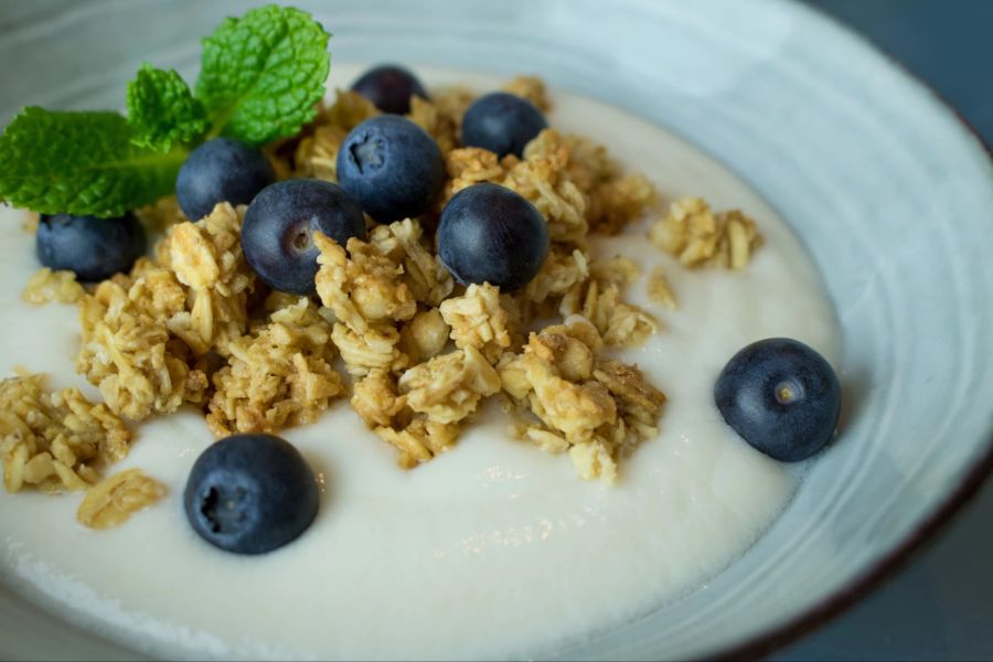 Foodfotografie einer Schüssel veganen Joghurts und Müsli.