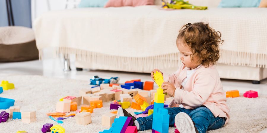 Kleines Mädchen spielt mit Bausteinen