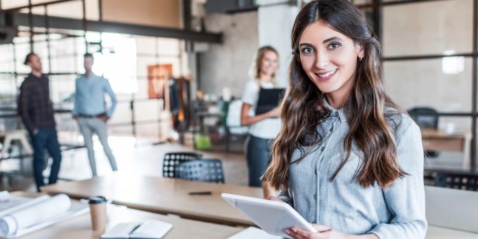Um ein Arbeitsumfeld zu schaffen, das alle Mitarbeiter fair behandelt, sollten Unternehmen Richtlinien einführen, die auch die Bedürfnisse von Singles ansprechen. Junge Geschäftsfrau mit digitalem Tablet