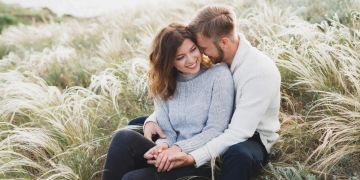 mann und frau umarmen sich, am strand sitzend