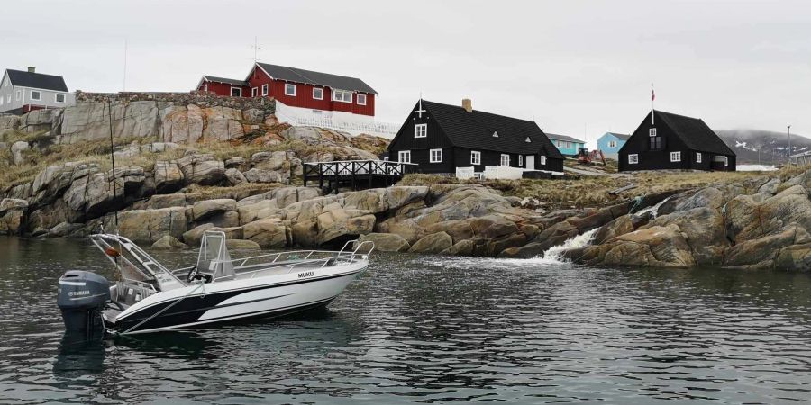 Grönland Häuser am Meer, mit Boot im Wasser.