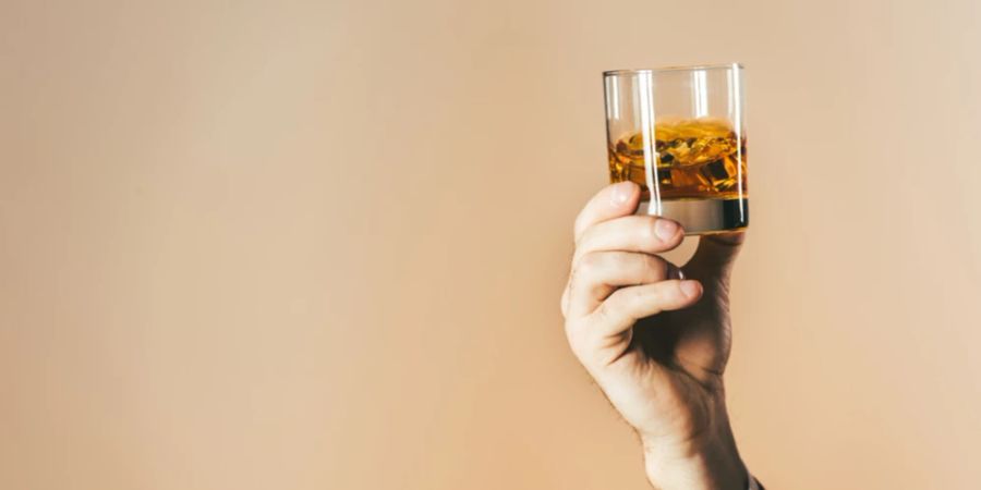 Mann Hand Arm Whiskey Glas beiger Hintergrund