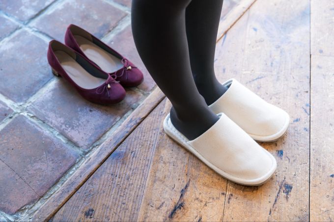 Vor dem Betreten die Schuhe auszuziehen, ist in Japan vielerorts selbstverständlich. Frau mit Hausschuhen