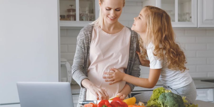 Schwangere Mutter Kind Küche Gemüse kochen