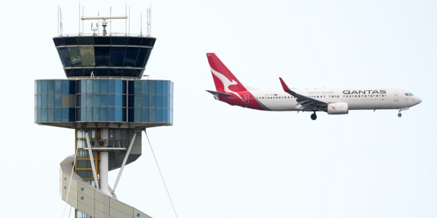 Ein Flugzeug von Qantas fliegt am Flugsicherungsturm des Flughafens Sydney vorbei. Foto: Bianca De Marchi/AAP/dpa