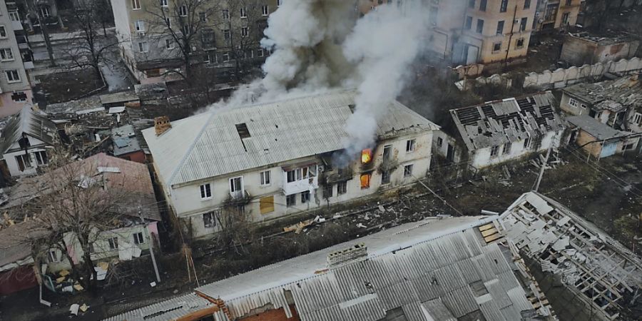 Rauch steigt aus einem brennenden Gebäude in einer Luftaufnahme von Bachmut auf, dem Ort schwerer Kämpfe mit russischen Truppen in der Region Donezk. Foto: Libkos/AP/dpa