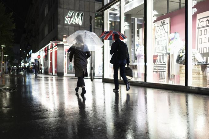 Passanten gehen abends nach Ladenschluss durch die von der Beleuchtung von Schaufenstern erhellte Bahnhofstrasse in Zürich. zürich energie