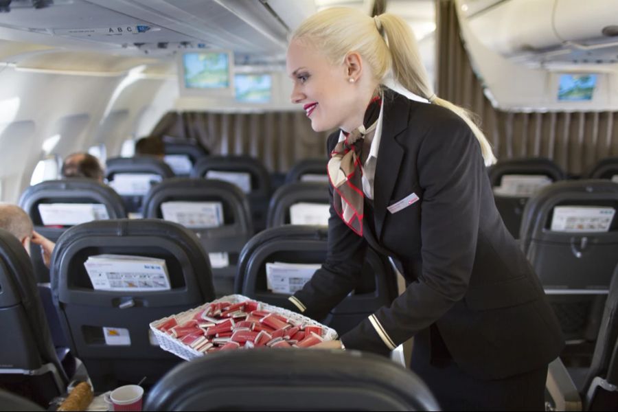 Ein Mitglied der Swiss-Cabin-Crew verteilt Schokolade-Täfelchen.