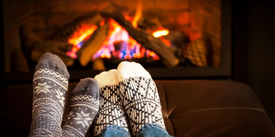 Füsse mit Wintersocken vor Kamin