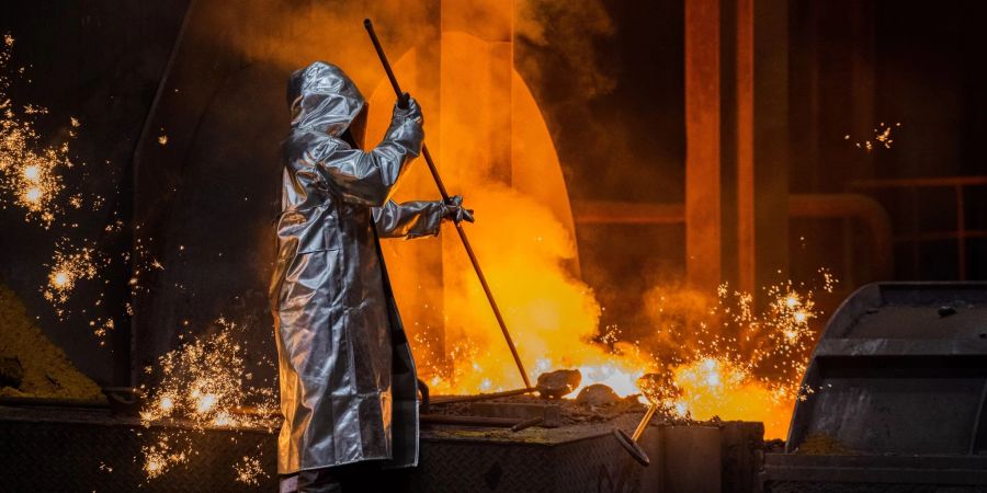 Ein Stahlarbeiter von Thyssenkrupp prüft den Roheisen am Hochofen.