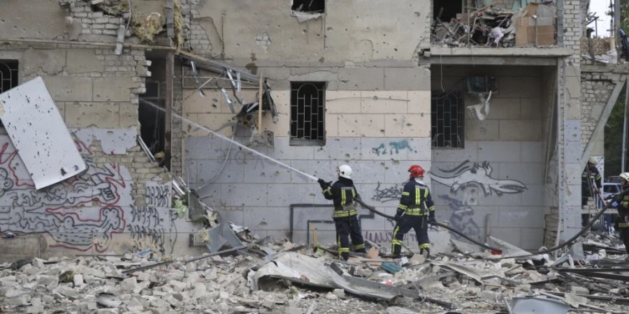 Ukrainische Feuerwehrleute löschen ein Feuer nach einem Luftangriff, der ein Wohnhaus beschädigt hat. Foto: Alex Babenko/AP/dpa