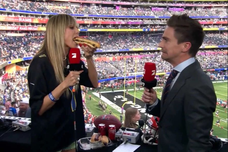 Heidi Klum beisst in einen Hot Dog.