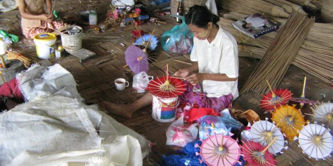 Eine Frau stellt kleine Schirme in Myanmar her. (Archivbild) Coronavirus