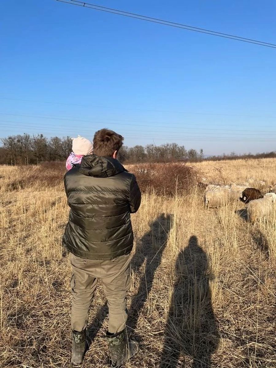 Ilja und das kleine Töchterchen beobachten die Schafe auf dem Feld. Hierhin sind sie aus dem Ukraine-Krieg geflohen, weiter kommen sie nicht.