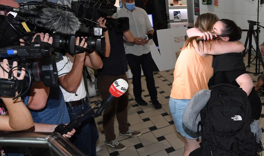 Eine Passagierin wird bei ihrer Ankunft am Flughafen Brisbane in die Arme genommen.