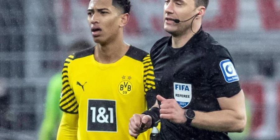Schiedsrichter Felix Zwayer (r) läuft an Dortmunds Jude Bellingham vorbei um sich den Videobeweis anzuschauen. Foto: Bernd Thissen/dpa