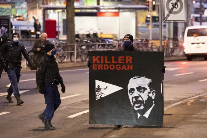 Polizisten entfernen ein von Demonstranten mitgebrachtes Plakat mit der Aufschrift «Killer Erdogan», vor dem Regionalgericht Bern-Mittelland, am Dienstag, 18. Januar 2022.. Erdogan Plakat Prozess