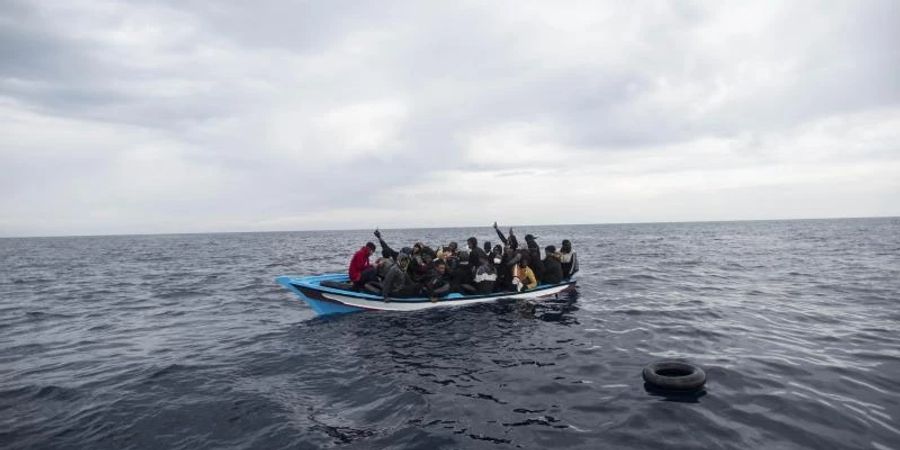 Ein Holzboot mit 28 Flüchtlingen aus Afrika und dem Maghreb wird von der Nichtregierungsorganisation Open Arms vor der libyschen Küste im Mittelmeer gerettet (Symbolbild). Foto: Andoni Lubaki/AP/dpa