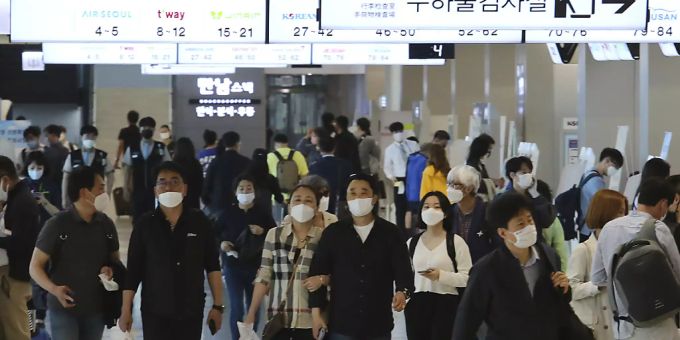 Menschen mit Mundschutz gehen am Flughafen Gimpo durch die Gänge des Inlandsterminals. Die Behörden haben alle Flugzeugpassagiere auf Grund der Corona-Pandemie zum Tragen von Gesichtsmasken aufgefordert. Foto: Ahn Young-Joon/AP/dpa Menschen mit Mundschutz gehen am Flughafen Gimpo durch die Gänge des Inlandsterminals. Die Behörden haben alle Flugzeugpassagiere auf Grund der Corona-Pandemie zum Tragen von Gesichtsmasken aufgefordert. Foto: Ahn Young-Joon/AP/dpa