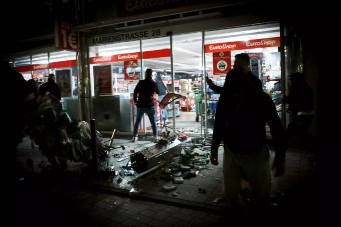Menschen stehen vor einem geplünderten Geschäft in der Marienstrasse. Bei Auseinandersetzungen mit der Polizei haben dutzende gewalttätige Kleingruppen die Innenstadt verwüstet und mehrere Beamte verletzt. Randale Plünderungen in Stuttgart