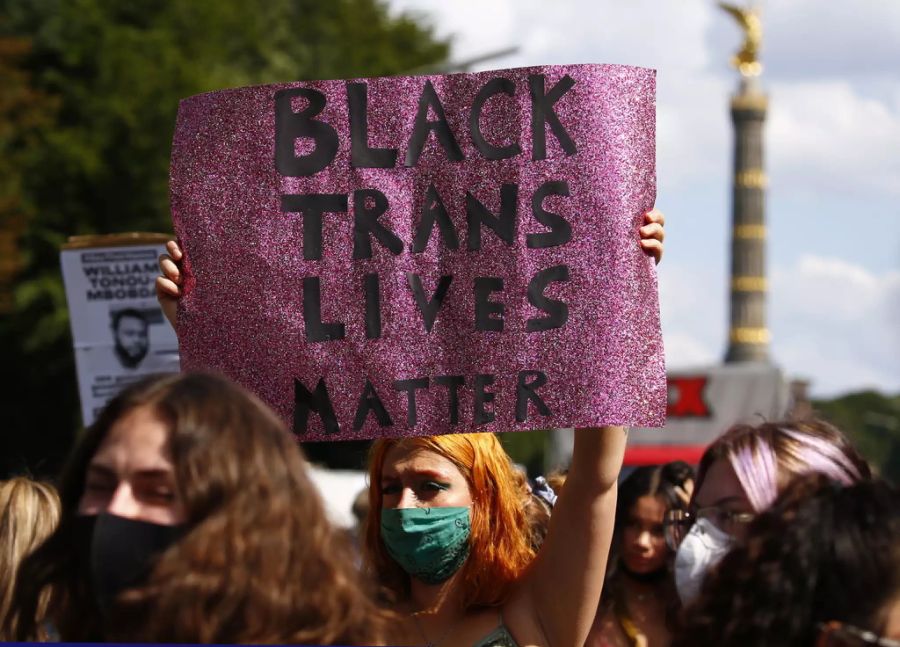 Eine Demonstrantin in Berlin hält ein Plakat mit der Aufschrift «Black Trans Lives Matter».