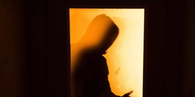 Der Schatten eines Mannes hinter einer gläsernen Wohnungstür. Foto: Nicolas Armer/Symbolbild/dpa Einbruch Coronavirus