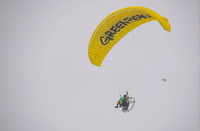 Ein Greenpeace-Aktivist fliegt mit seinem Gleitschirm in Richtung Fleischfabrik Tönnies. tönnies