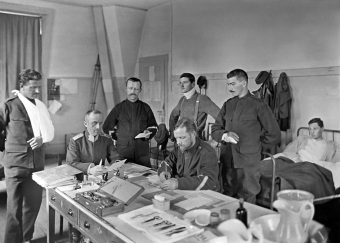 Ein Truppenarzt untersucht während des Ersten Weltkrieges Schweizer Armeeangehörige in einem Krankenzimmer auf die Spanische Grippe. Spanische Grippe