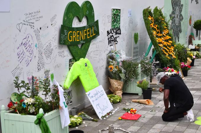 Ein Mann kniet am Grenfell Memorial Community Mosaik am Fusse des Grenfell Towers am dritten Jahrestag des Brandes im Grenfell Tower, bei dem 72 Menschen starben. Gedenktag an