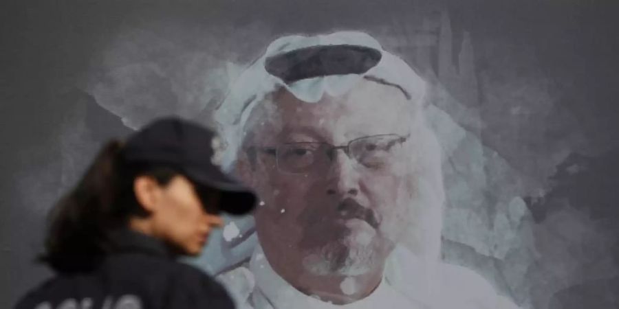 Eine Polizistin geht in der Nähe des saudischen Konsulats in Istanbul an einem Wandbild des ermordeten Journalisten Jamal Khashoggi vorbei. Foto: Lefteris Pitarakis/AP/dpa